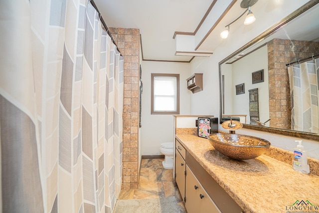 bathroom featuring walk in shower, vanity, ornamental molding, and toilet