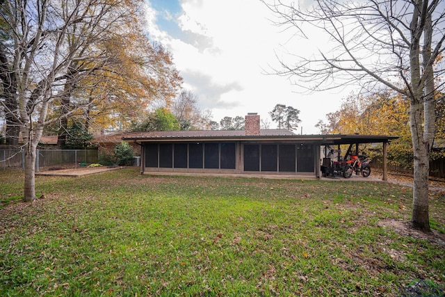 view of yard with a sunroom and a carport