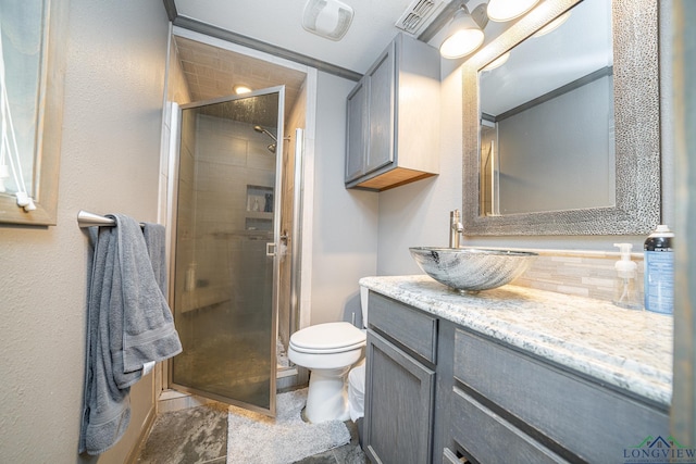 bathroom featuring vanity, a shower with shower door, and toilet