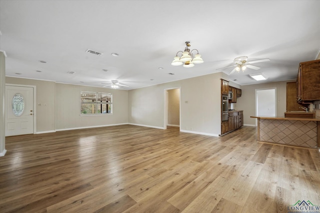 1480 Woodland Dr, Canton, TX 75103 - unfurnished living room with ceiling fan with notable chandelier and light hardwood / wood-style flooring