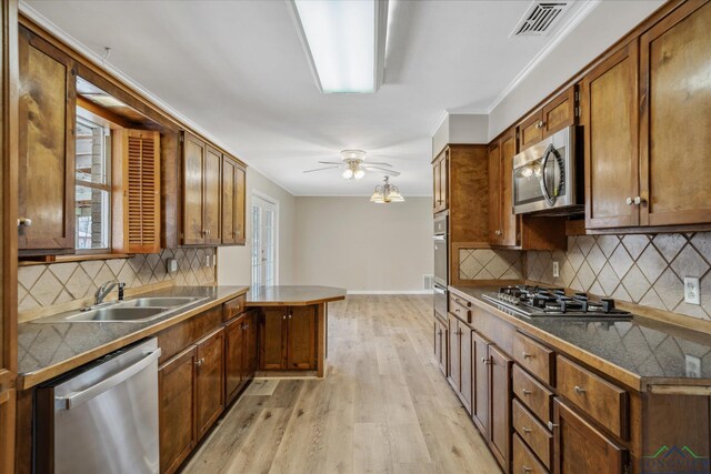 1480 Woodland Dr, Canton, TX 75103 - kitchen with appliances with stainless steel finishes, sink, backsplash, ceiling fan, and light wood-type flooring