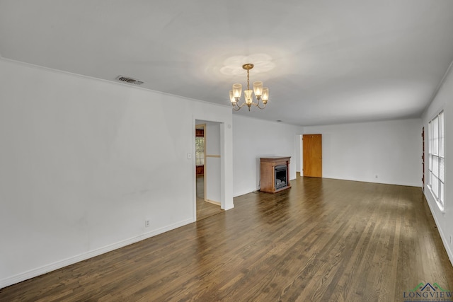 unfurnished living room with dark hardwood / wood-style flooring and a notable chandelier