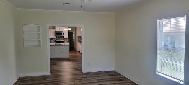 unfurnished room featuring crown molding, plenty of natural light, and dark hardwood / wood-style floors