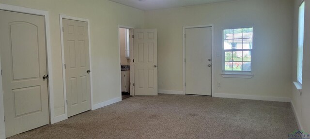 unfurnished bedroom featuring light carpet