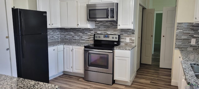 kitchen with light stone counters, stainless steel appliances, and white cabinets