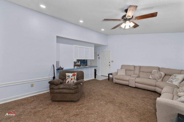 carpeted living room with ceiling fan and a textured ceiling