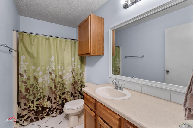 bathroom featuring tile patterned flooring, vanity, toilet, and a textured ceiling