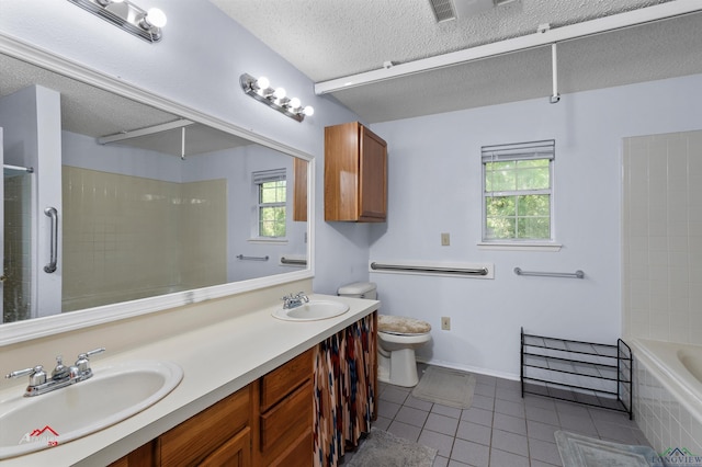 full bathroom with tile patterned floors, a textured ceiling, vanity, tiled shower / bath combo, and toilet