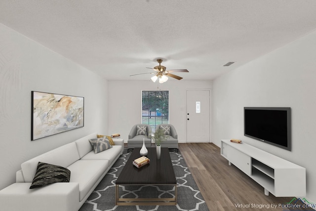 living room featuring ceiling fan, wood-type flooring, and a textured ceiling