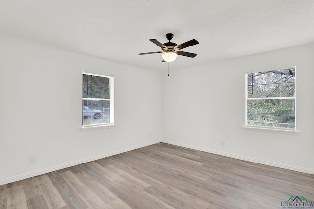 empty room with ceiling fan and light wood-type flooring