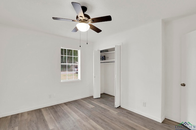 unfurnished bedroom with ceiling fan, light wood-type flooring, and a closet