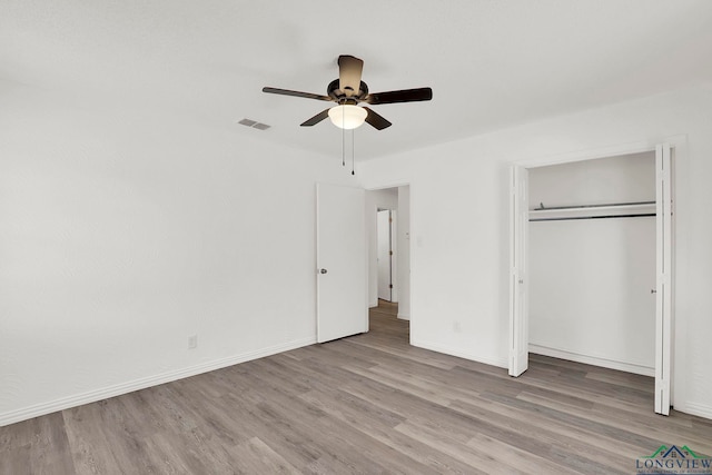 unfurnished bedroom with a closet, light hardwood / wood-style flooring, and ceiling fan