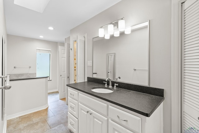 bathroom with recessed lighting, tile patterned floors, vanity, a closet, and baseboards