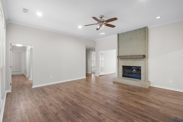 unfurnished living room featuring wood finished floors, visible vents, a ceiling fan, ornamental molding, and a fireplace