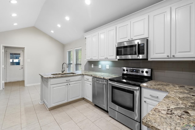 kitchen featuring a peninsula, tasteful backsplash, stainless steel appliances, and a sink