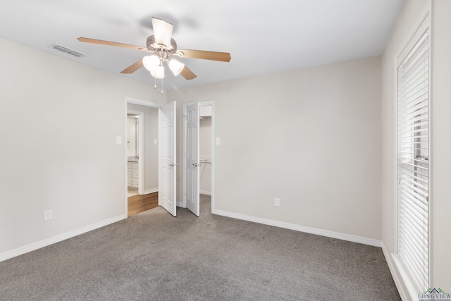 unfurnished bedroom with baseboards, visible vents, carpet floors, and multiple windows