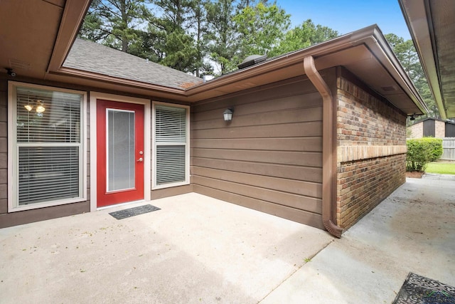 entrance to property with brick siding and a patio area