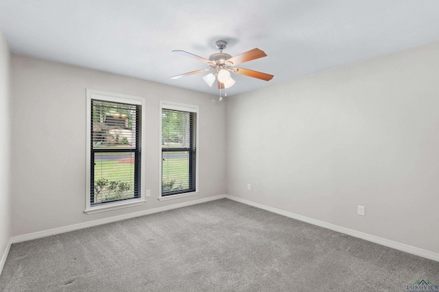carpeted spare room with baseboards and ceiling fan