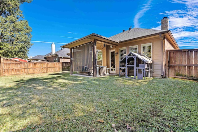 back of house featuring a yard and a sunroom