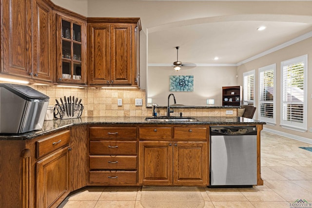 kitchen with dark stone counters, kitchen peninsula, sink, and stainless steel dishwasher