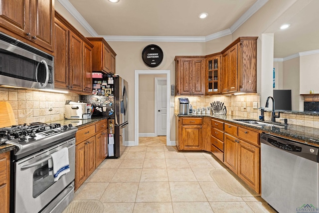 kitchen featuring appliances with stainless steel finishes, light tile patterned floors, crown molding, and sink