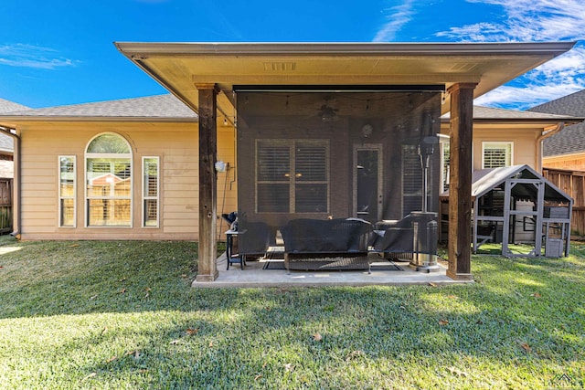 rear view of property with a lawn, ceiling fan, and a patio