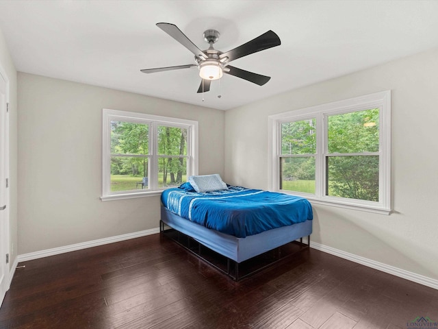 bedroom featuring multiple windows, ceiling fan, and dark hardwood / wood-style floors