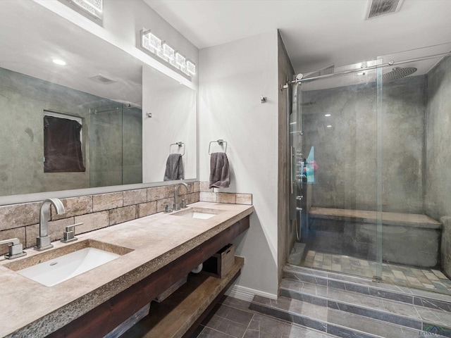 bathroom featuring decorative backsplash, vanity, and an enclosed shower