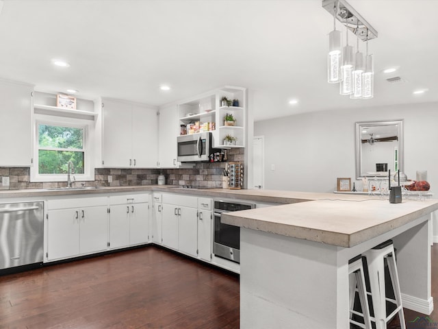 kitchen with white cabinetry, sink, ceiling fan, stainless steel appliances, and pendant lighting