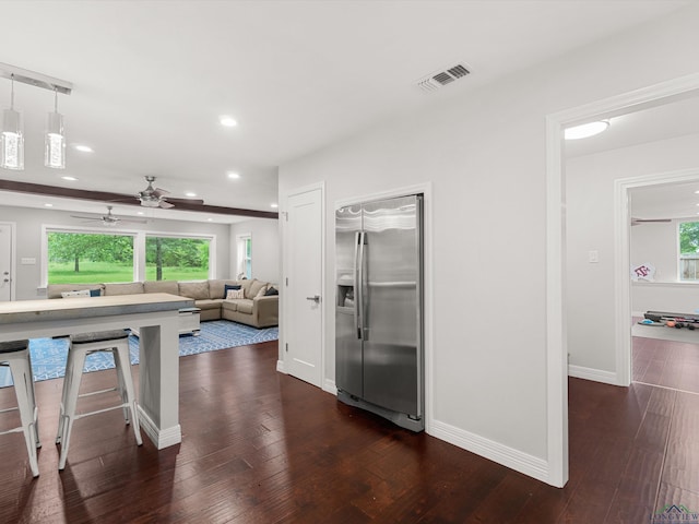 interior space featuring built in fridge, pendant lighting, dark wood-type flooring, and a wealth of natural light