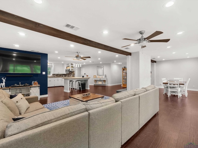 living room with dark hardwood / wood-style floors, beam ceiling, and ceiling fan