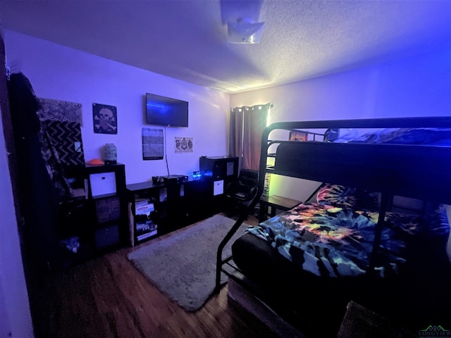 bedroom with wood-type flooring and a textured ceiling