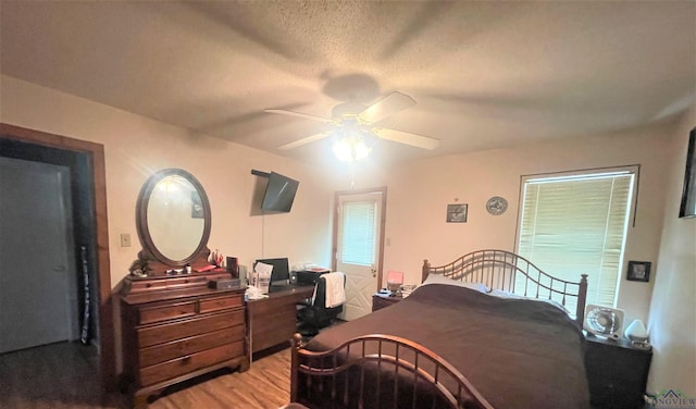 bedroom with ceiling fan, a textured ceiling, and hardwood / wood-style flooring