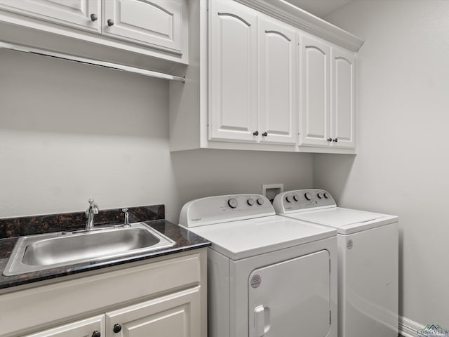 clothes washing area with sink, cabinets, and washing machine and clothes dryer