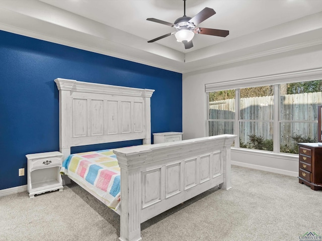 bedroom featuring light carpet, a raised ceiling, and ceiling fan