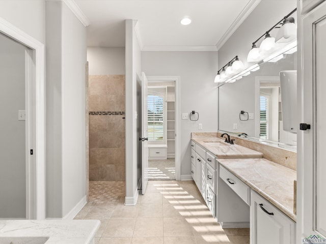 bathroom with crown molding, a tile shower, vanity, and tile patterned floors