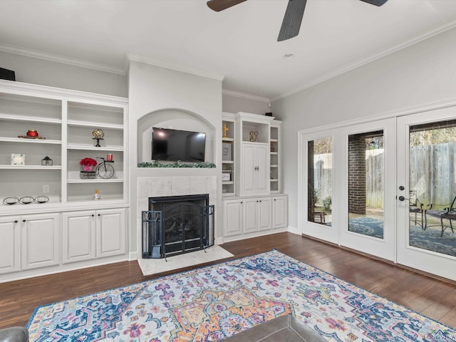 living room with dark hardwood / wood-style flooring, a fireplace, ornamental molding, and ceiling fan