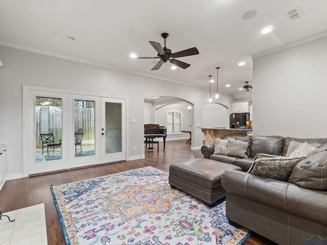 living room featuring wood-type flooring, ceiling fan, and crown molding