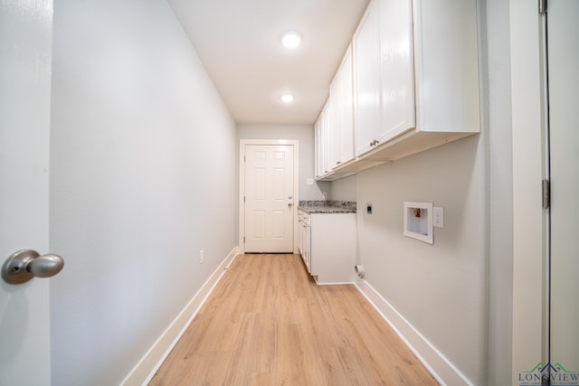 laundry area featuring electric dryer hookup, hookup for a washing machine, cabinets, and light hardwood / wood-style floors