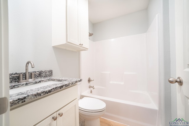 full bathroom featuring vanity, toilet, wood-type flooring, and bathing tub / shower combination