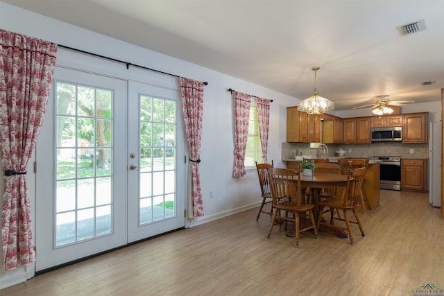 dining area with ceiling fan with notable chandelier, a wealth of natural light, and sink