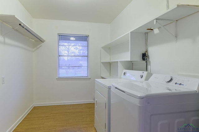 clothes washing area with washer and dryer and light hardwood / wood-style floors