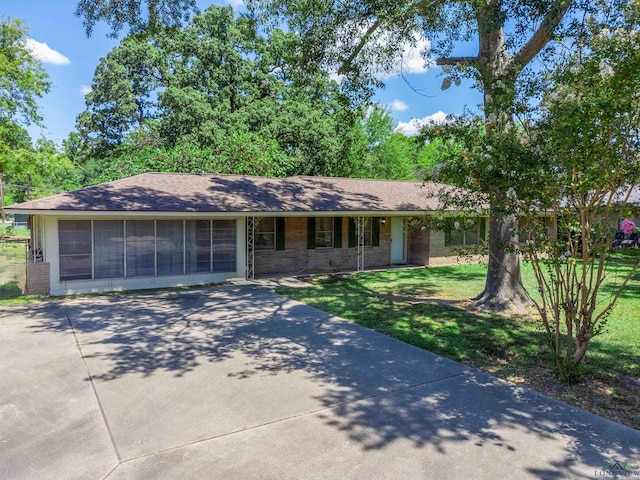 ranch-style house with a sunroom and a front lawn