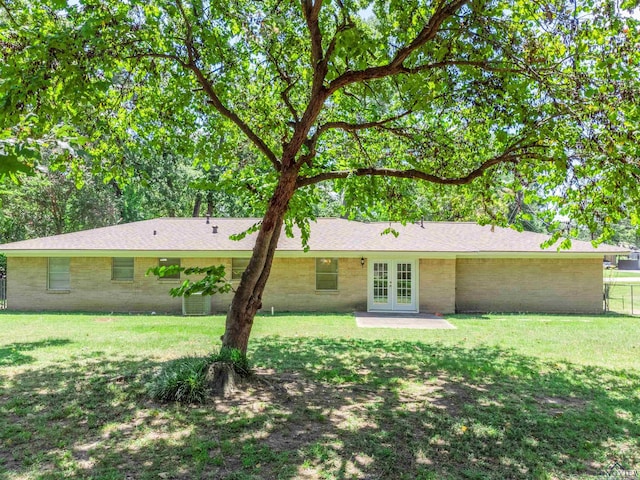 back of house featuring french doors and a lawn