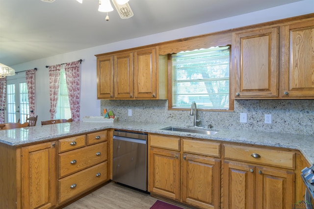 kitchen featuring tasteful backsplash, kitchen peninsula, dishwasher, and sink