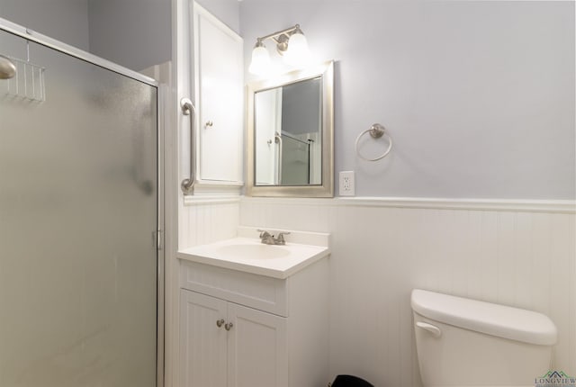 bathroom with vanity, toilet, and a shower with shower door