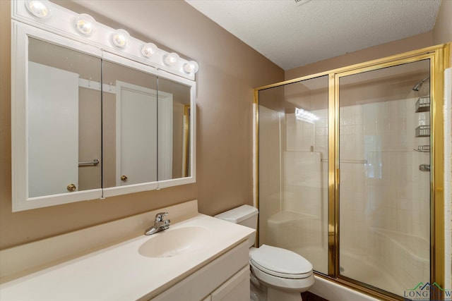 bathroom with vanity, toilet, a textured ceiling, and walk in shower