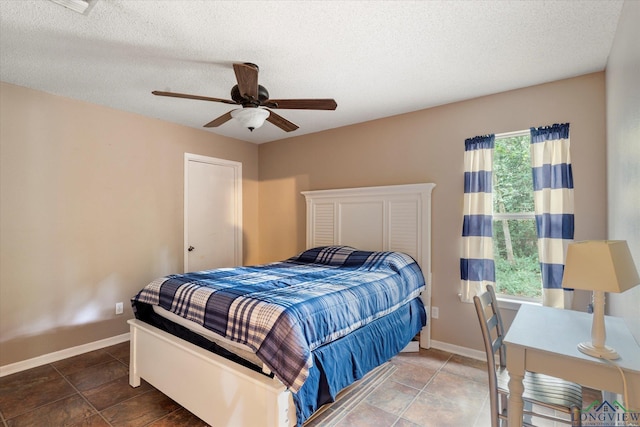 bedroom featuring ceiling fan and a textured ceiling