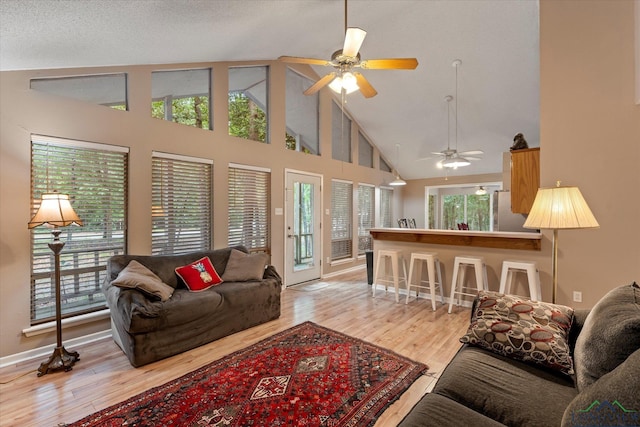 living room with a wealth of natural light, ceiling fan, and light hardwood / wood-style floors