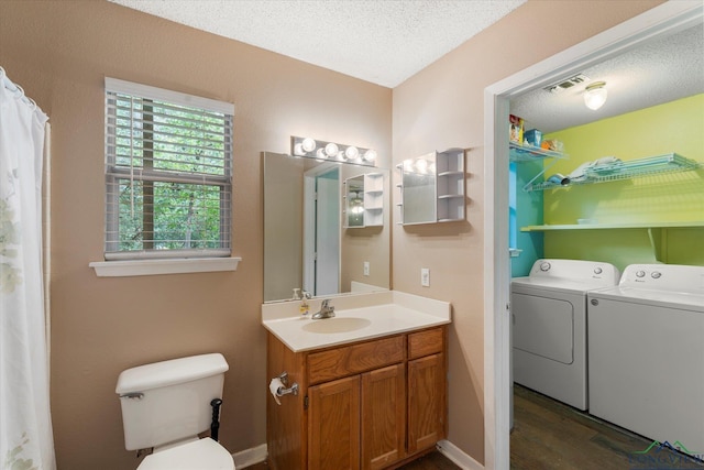 bathroom with separate washer and dryer, hardwood / wood-style floors, a textured ceiling, toilet, and vanity